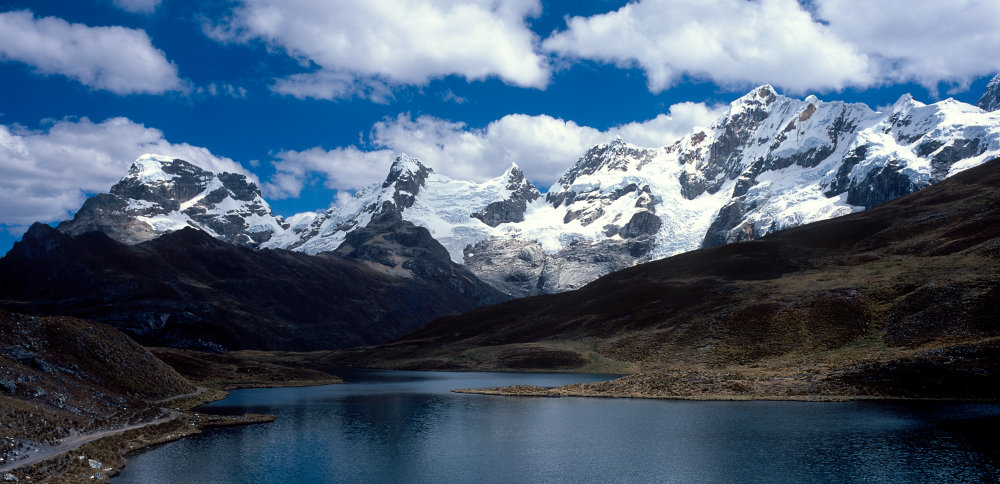 La Laguna Huaracacocha (4540 m) est proche de notre campement à Huayhuash. Elle est dominée de gauche à droite par le Trapecio (5653 m), le Quesillo (5600 m), le Huaraca (5537 m) et le Jurau (5674 m). Même si les glaciers peuvent sembler imposants, nos guides nous apprennent qu'au fil des années, ils les voient diminuer.<br />Prise de vue : 18/07/08, 13h00