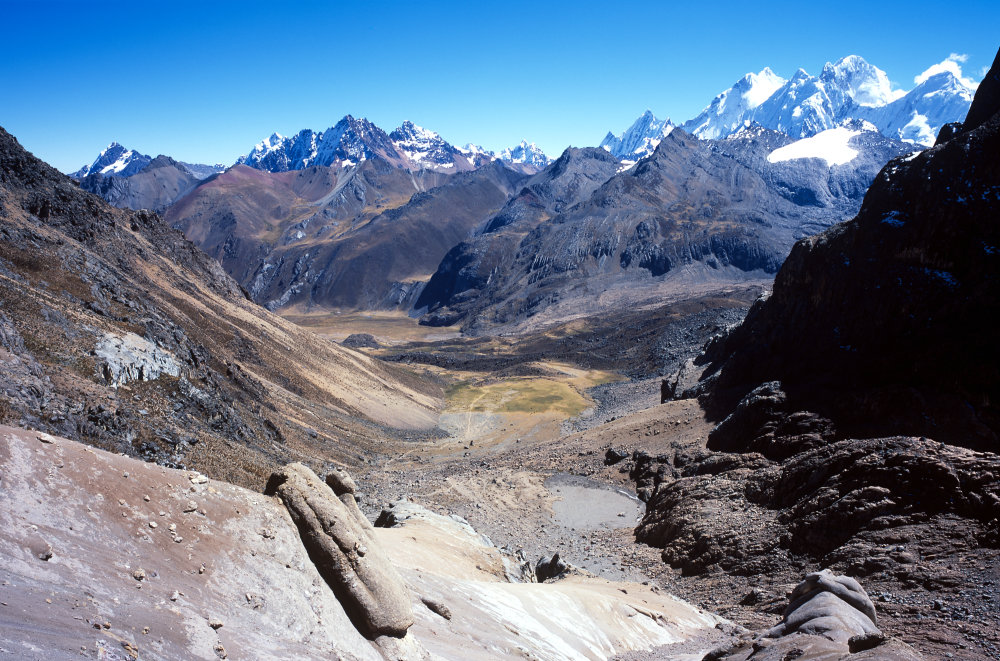 Notre regard plonge dans la descente qui nous attend au travers des cailloux, rochers et poussière. Au fond se trouve Rasac (6017 m), Seria (5860 m) et son glacier.<br />Prise de vue : 20/07/08, 10h55